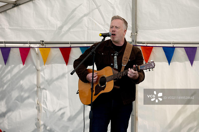 在英国沃里克郡皇家利明顿温泉镇公园艺术节上表演的歌手/吉他手图片素材
