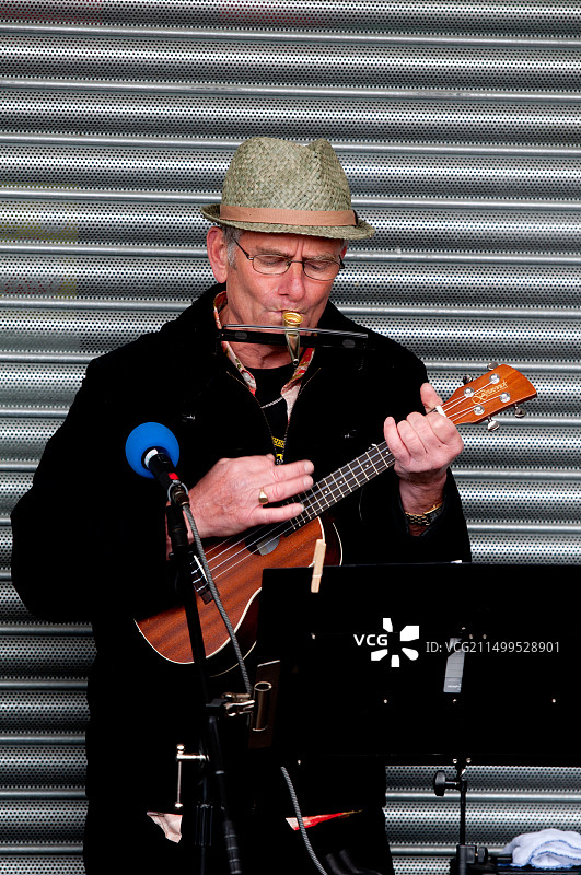 在尤克里里乐队里吹卡祖笛的男人图片素材