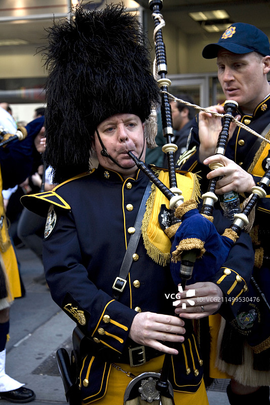爱尔兰风笛乐队的成员正在调音，准备参加纽约市的圣帕特里克节游行图片素材