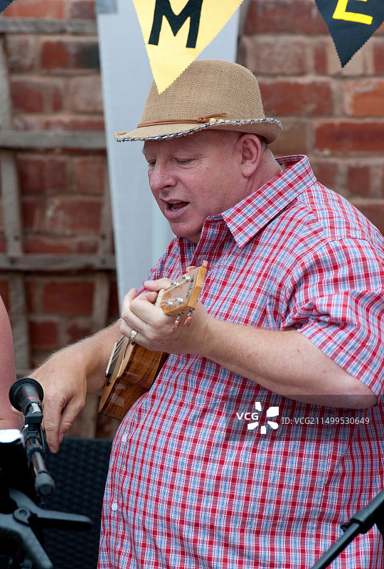 男人唱歌并弹奏尤克里里图片素材