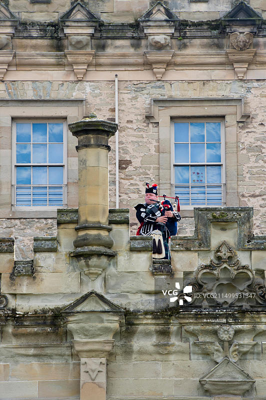 在苏格兰凯尔索弗洛尔城堡壁垒上的孤独风笛手图片素材