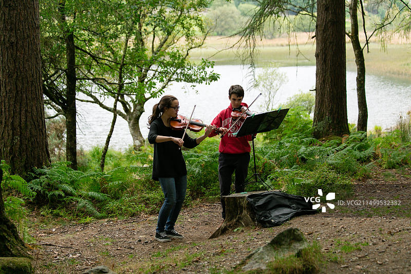 在爱尔兰威克洛郡格兰达洛山谷小路上演奏古典音乐的小提琴手图片素材