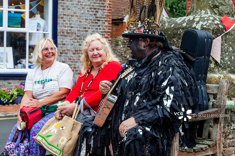 莫里斯舞者与当地人交谈，英国苏塞克斯郡阿尔弗里斯顿集市图片素材