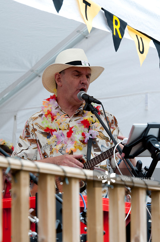 男人唱歌和弹奏尤克里里。图片素材