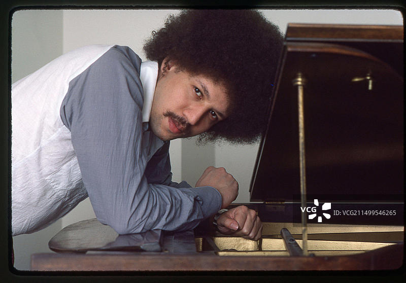 爵士钢琴家兼作曲家安东尼·戴维斯在纽约曼哈顿的家中，钢琴旁的肖像照，1983年图片素材