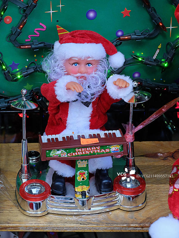 在纽约皇后区杰克逊高地罗斯福大道上演奏鼓和键盘的愚蠢的圣诞老人发条玩具图片素材