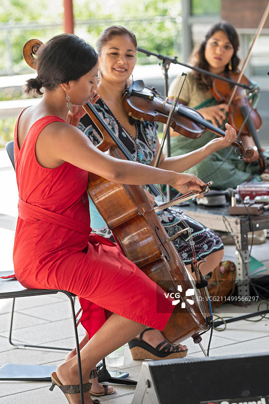 三位音乐家在法拉盛皇后植物园的音乐会上表演图片素材