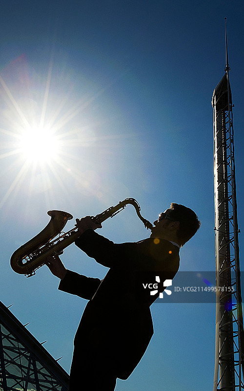 在格拉斯哥科学中心背景下吹萨克斯的男子轮廓图片素材