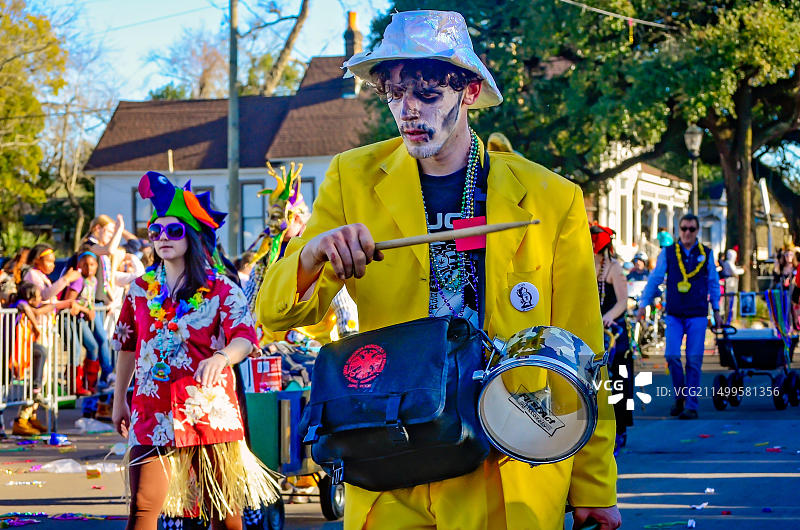 在莫比尔的乔·凯恩日狂欢节游行中，一个打扮成骷髅绅士的男人敲着小鼓图片素材