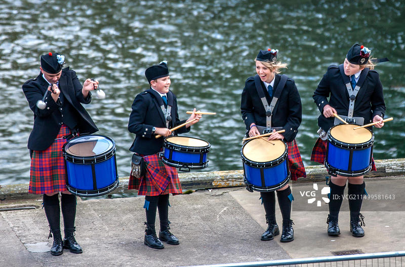 苏格兰乐队在苏格兰因弗戈登港迎接远洋轮船图片素材