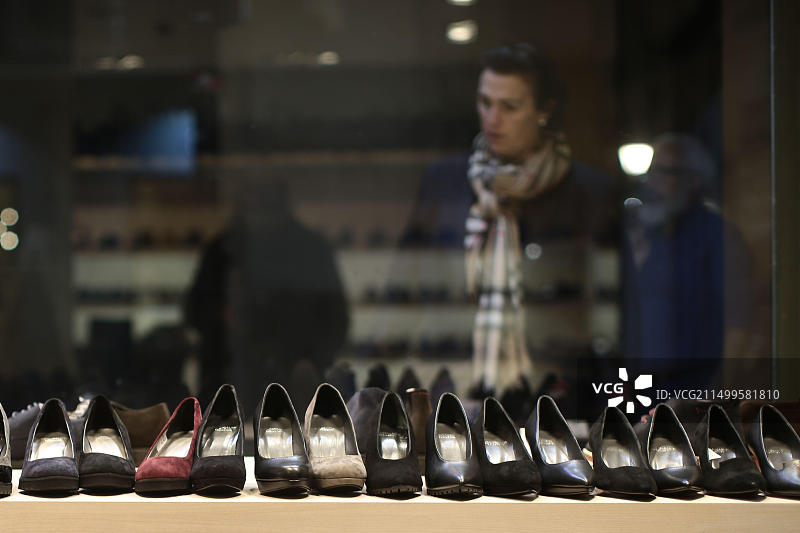 购物者在商店橱窗里看各种鞋子，西班牙首都马德里的一般景观图片素材