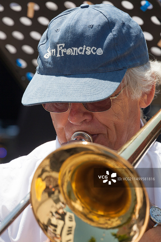 戴棒球帽的男性长号演奏者特写图片素材