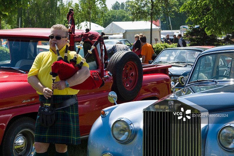 风笛手在劳斯莱斯银云汽车旁演奏苏格兰风笛图片素材