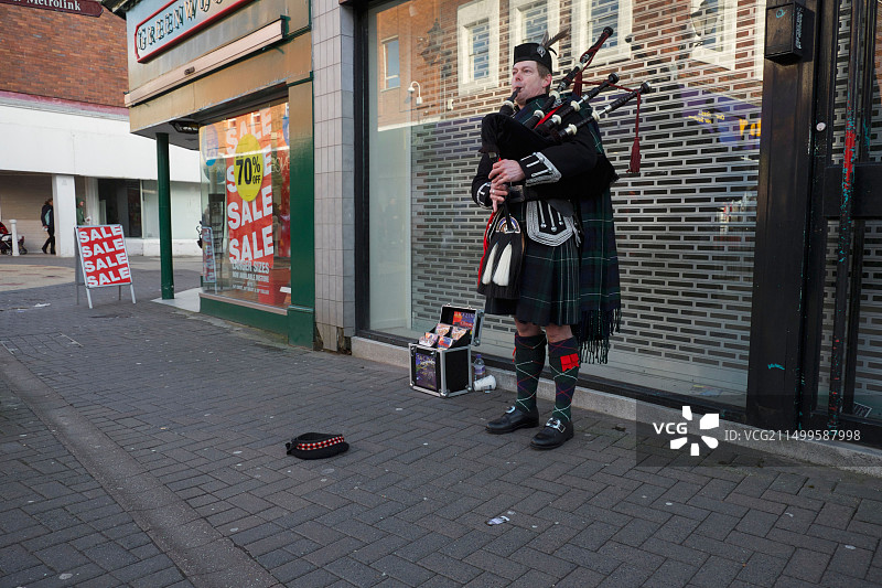 在英国柴郡奥尔特灵厄姆街头购物时演奏的街头音乐家图片素材