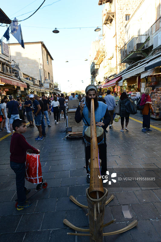 在耶路撒冷马哈内·耶胡达市场演奏迪吉里杜管的街头艺人图片素材