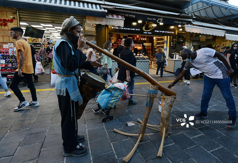 在耶路撒冷马哈内·耶胡达市场演奏迪吉里杜管的街头艺人图片素材