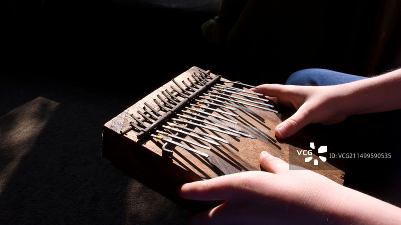 男孩演奏姆比拉拇指琴图片素材