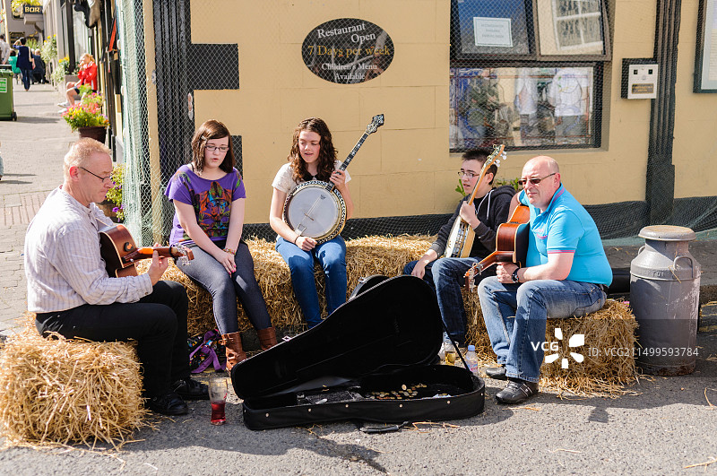 传统音乐家在干草堆上演奏乐器和唱歌图片素材