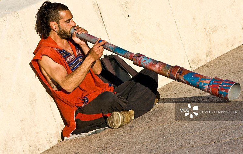 街头艺人在西班牙科尔多瓦罗马桥上演奏迪吉里杜管图片素材