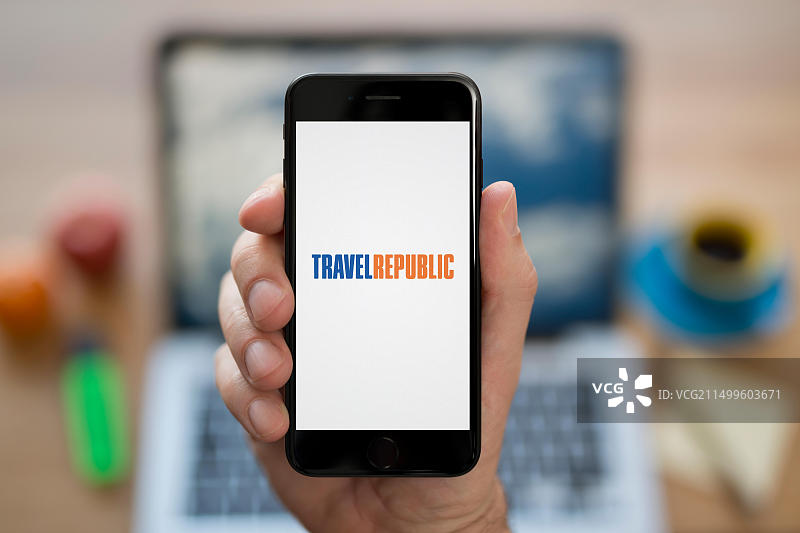 一名男子看着显示Travel Republic标志的iPhone（仅限编辑使用）图片素材