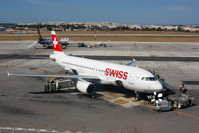 欧洲商业航空旅行：乘客在马耳他国际机场登上瑞士国际航空空客A320飞机图片素材