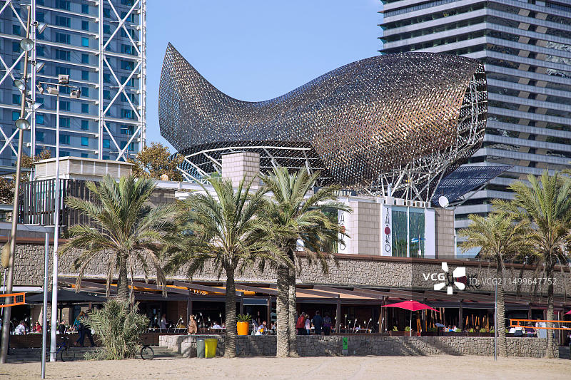 西班牙巴塞罗那巴塞罗内塔海滩和奥林匹克港口的金色鱼雕塑图片素材