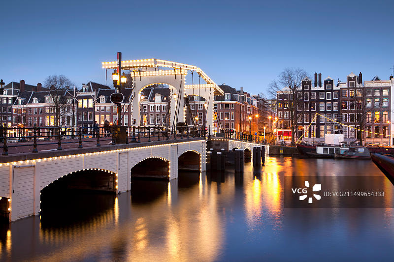 荷兰阿姆斯特丹：阿姆斯特尔河畔的17世纪房屋，背景为瘦桥，联合国教科文组织世界遗产图片素材