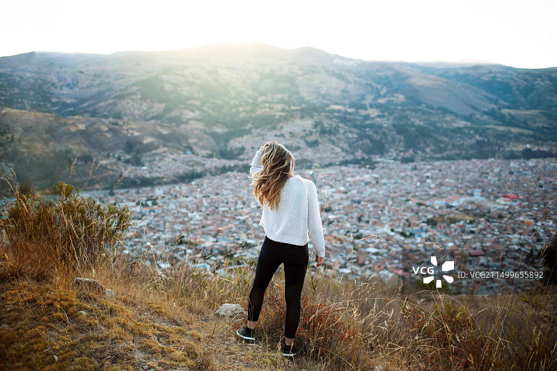 秘鲁瓦拉斯，欣赏风景，玩头发的女子背影。南美洲旅游生活方式，2018年7月图片素材