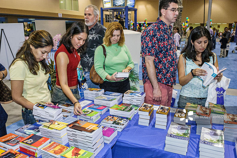 迈阿密佛罗里达州椰树林会议中心，迈阿密先驱报旅游博览会指南展示西班牙裔女性，购物者购物图片素材