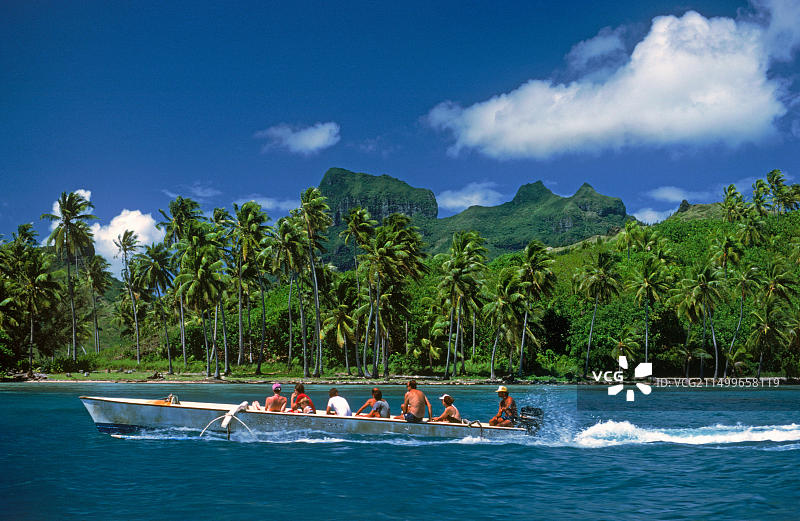 游客乘坐螃蟹船驶过法属波利尼西亚的波拉波拉岛图片素材