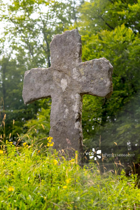 芬托夫特木板教堂的古老石十字架，周围环绕着树木，位于挪威霍达兰郡芬托夫特韦根天堂镇图片素材