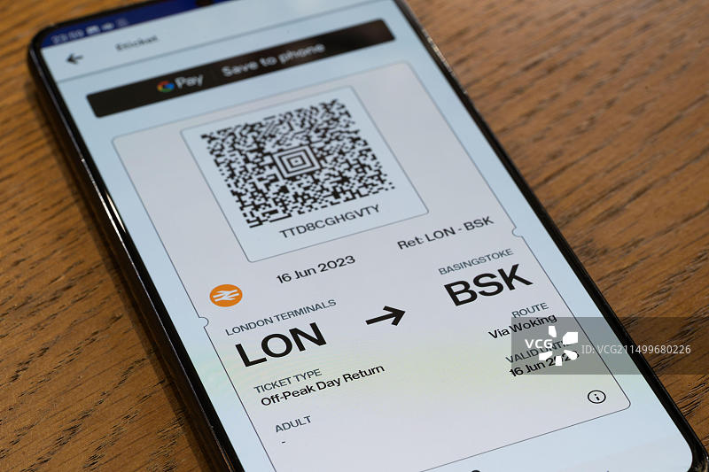 智能手机屏幕上使用Trainline App购买的从伦敦到贝辛斯托克的火车票二维码：火车旅行主题图片素材