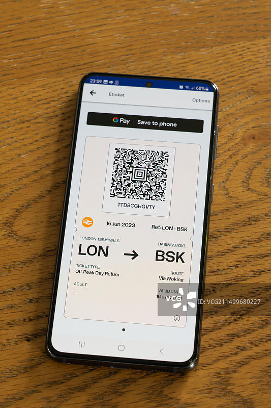 智能手机屏幕上使用Trainline App购买的从伦敦到贝辛斯托克的火车票二维码：火车旅行主题图片素材