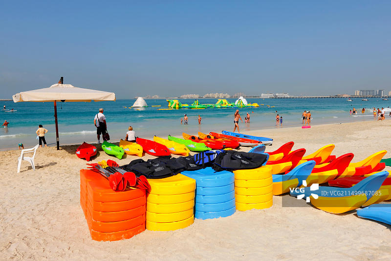 迪拜海滩：朱美拉海滩住宅区的彩色塑料皮划艇图片素材