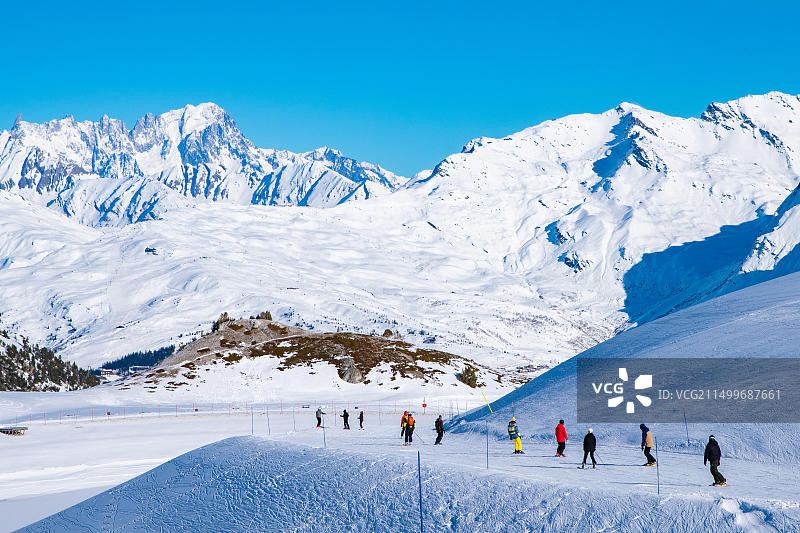 人们在阿尔卑斯山区享受滑雪和单板滑雪的冬季假期，背景是勃朗峰，法国萨瓦省莱萨尔克2000图片素材