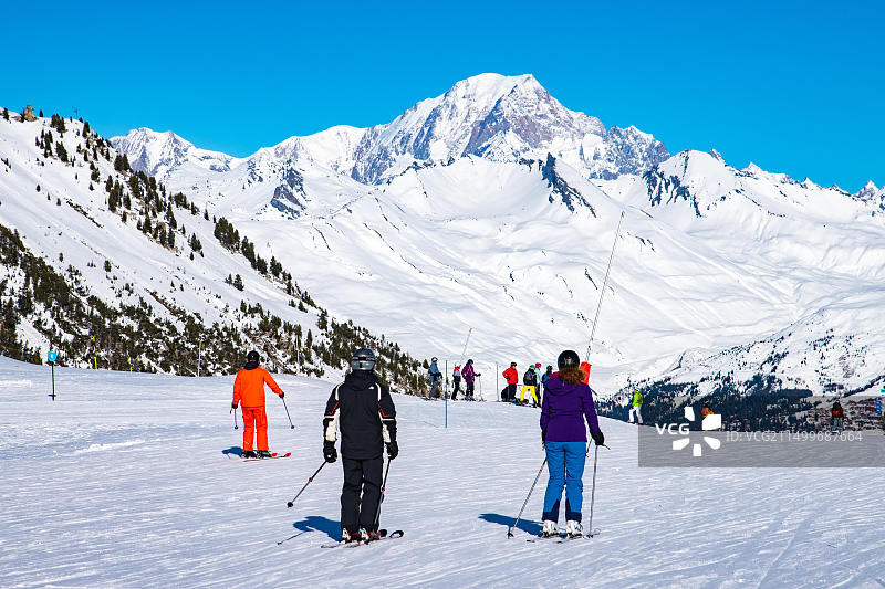人们在阿尔卑斯山区享受滑雪和单板滑雪的冬季假期，背景是勃朗峰，法国萨瓦省莱萨尔克2000图片素材