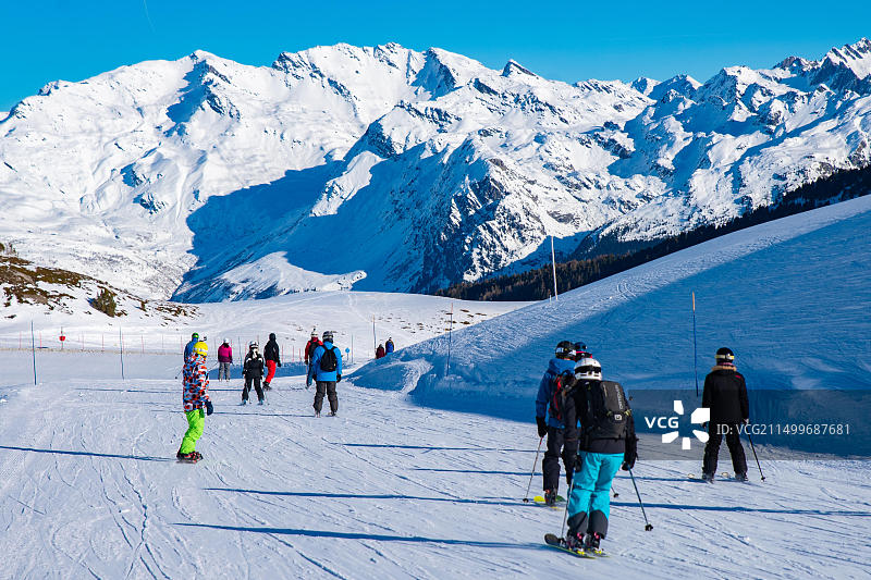 人们在阿尔卑斯山区享受滑雪和单板滑雪的冬季假期，背景是勃朗峰，法国萨瓦省莱萨尔克2000图片素材