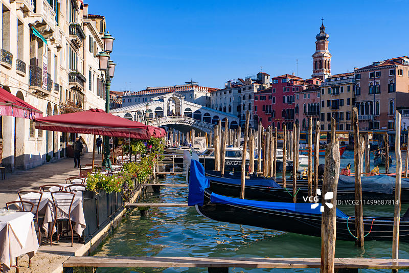 从意大利威尼斯户外餐厅座位欣赏大运河、里亚托桥和贡多拉图片素材