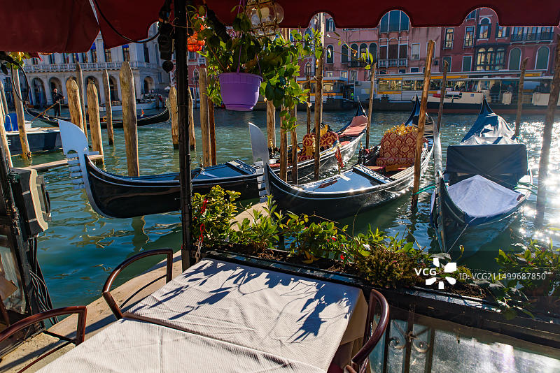 从意大利威尼斯户外餐厅座位欣赏大运河、里亚托桥和贡多拉图片素材