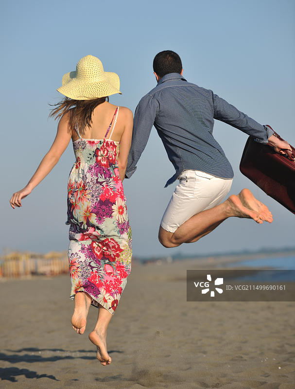 情侣在海滩旅行，带着旅行包图片素材