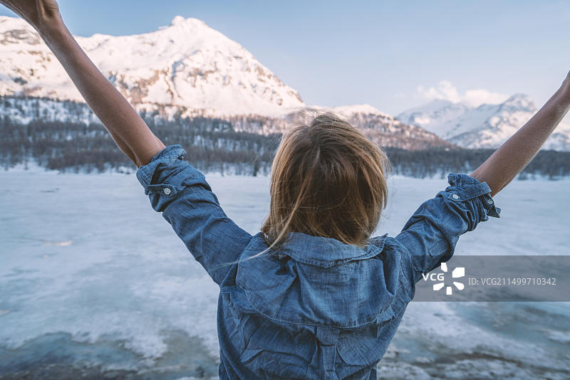 在瑞士山景中张开双臂的年轻女子图片素材