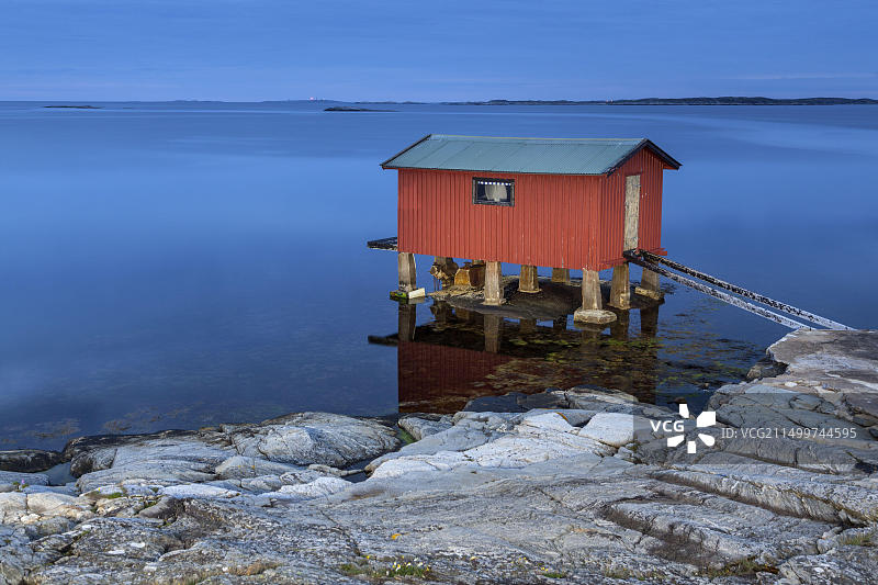 瑞典韦斯特拉约塔兰省奥鲁斯特岛海边红色小屋图片素材
