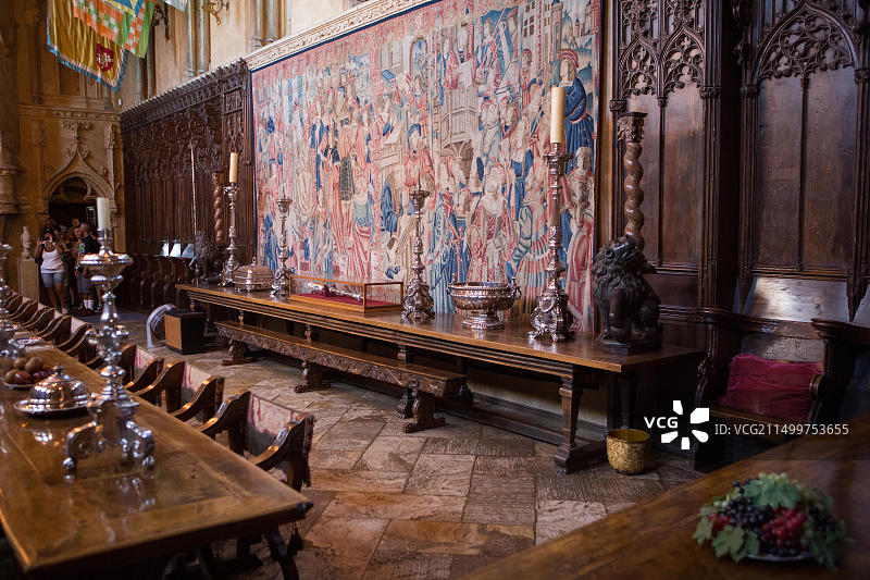 赫斯特城堡餐厅，游客参观内部家具、桌子、挂毯、雕塑和艺术品图片素材