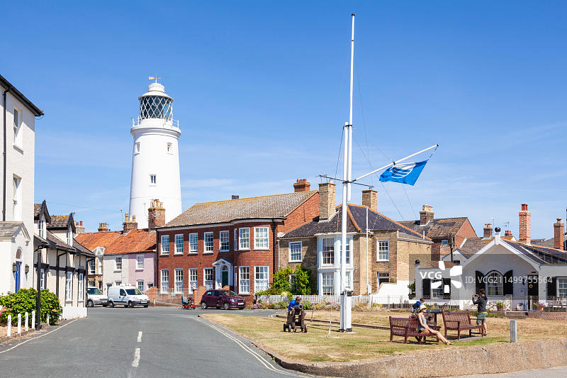 索斯沃尔德灯塔、房屋和长椅上的人们，位于英国萨福克郡图片素材