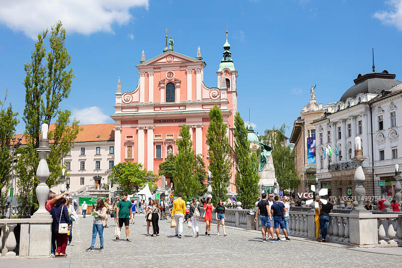 斯洛文尼亚卢布尔雅那市中心，普列舍伦广场的粉红色方济各教堂和三桥上的游客图片素材