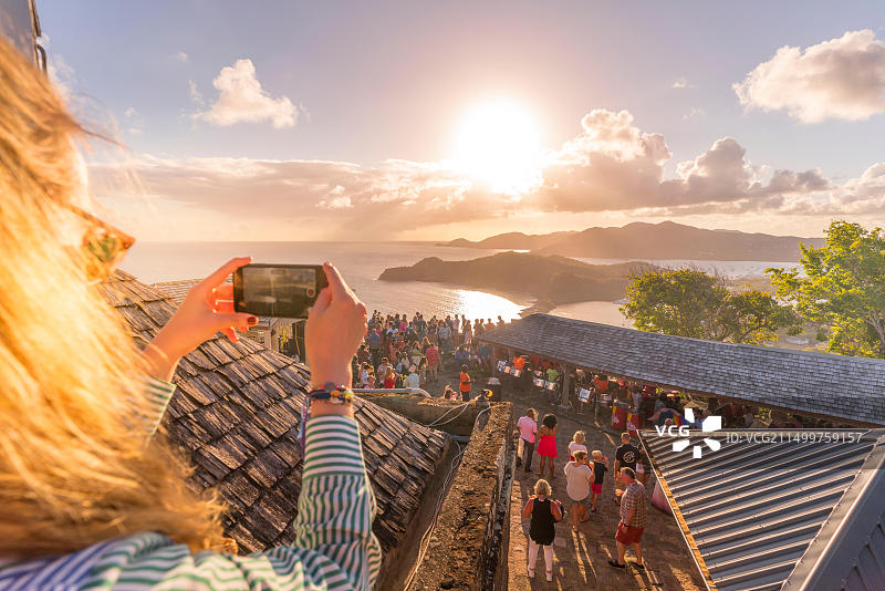 女子在日落派对上用智能手机拍照，地点：安提瓜和巴布达安提瓜岛雪莉高地，西印度群岛，加勒比海，中美洲图片素材