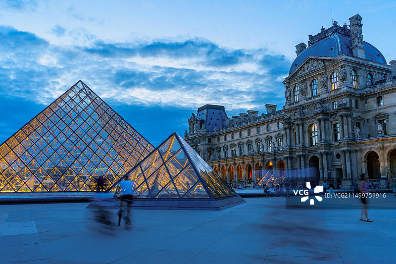 骑行者和游客在卢浮宫博物馆的庭院里。法国巴黎，2015年8月图片素材