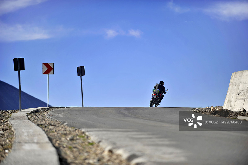 摩托车手在特兰斯阿尔皮纳公路上向右转弯图片素材