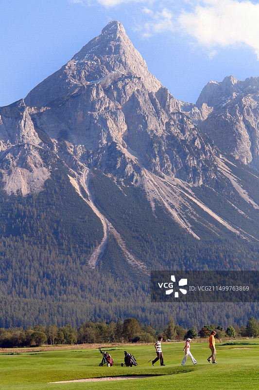 奥地利蒂罗尔埃尔瓦尔德，在松恩峰和格伦施泰因山背景下打高尔夫图片素材