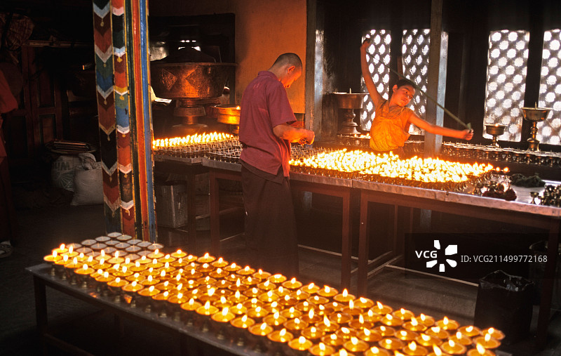 尼泊尔加德满都烧酥油灯的男子（斯瓦扬布纳特寺）图片素材